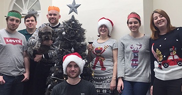 The Edge of the Web team celebrating around a christmas tree