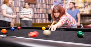 Team member taking a shot on a pool table