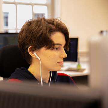 Front end developer coding with headphones in