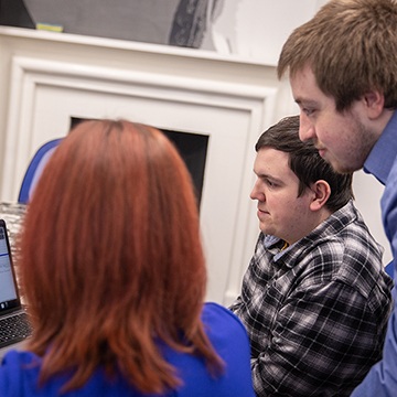 Project team members reviewing a website on a laptop