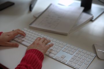 Close up of a woman's hands as she types alt text