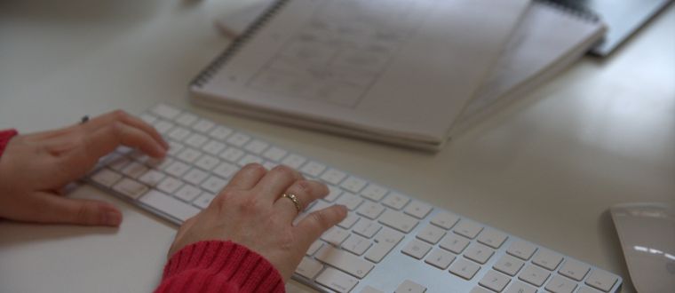 Close up of a woman's hands as she types alt text