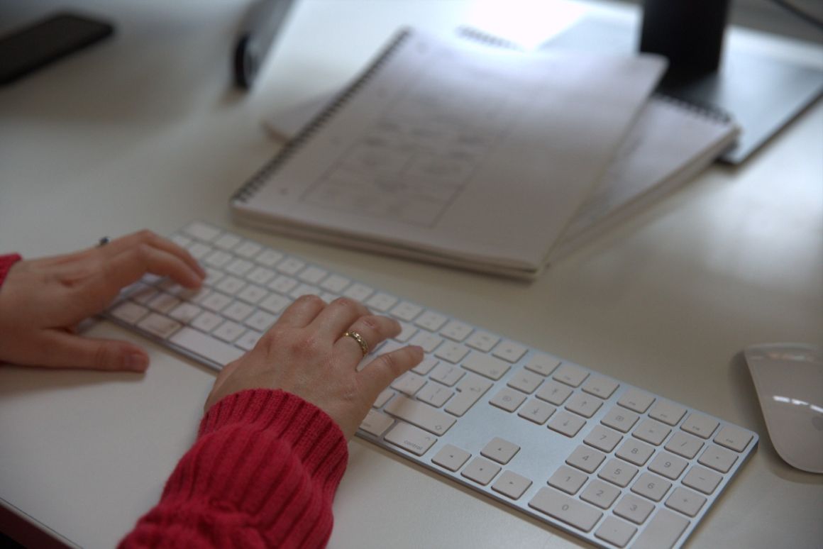 Close up of a woman's hands as she types alt text